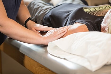 Therapist's hands on a patient's upper arm
