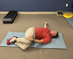 man laying on his side stretching his torso