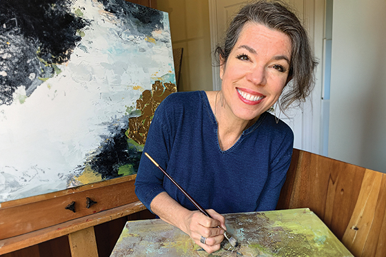 A female cancer survivor painting in her studio. 